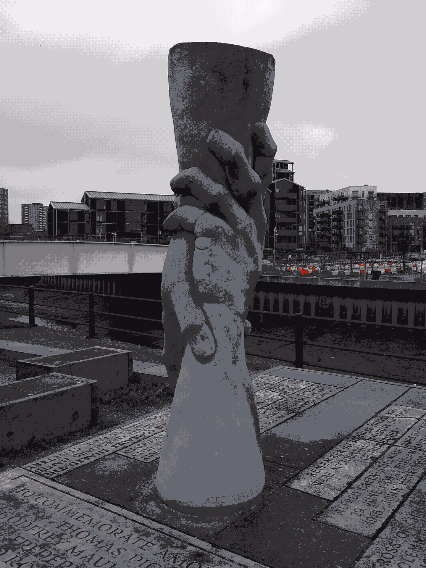 Stone sculpture of two hands holding each other at a memorial